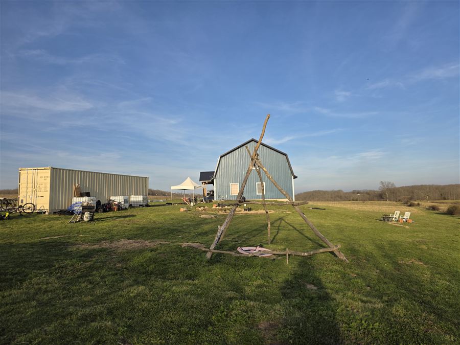 The farmstead at golden hour — container, barn, and open pasture