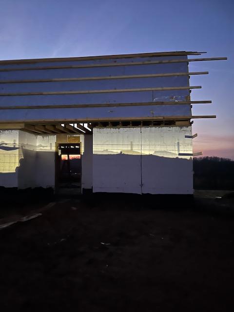 Rigid foam insulation boards installed across the roof plane, seen at dusk.