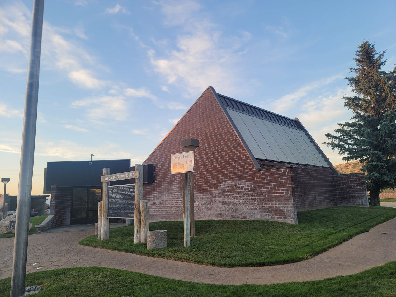 Brick rest area building with a steep south-facing roof plane fully glazed with solar collector panels, earth bermed at the base.